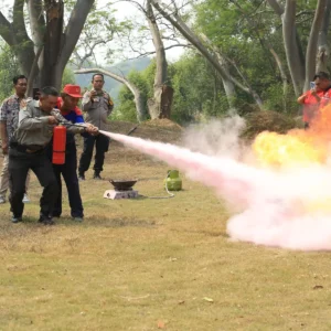 Trainee putting out a controlled training fire with a fire extinguisher
