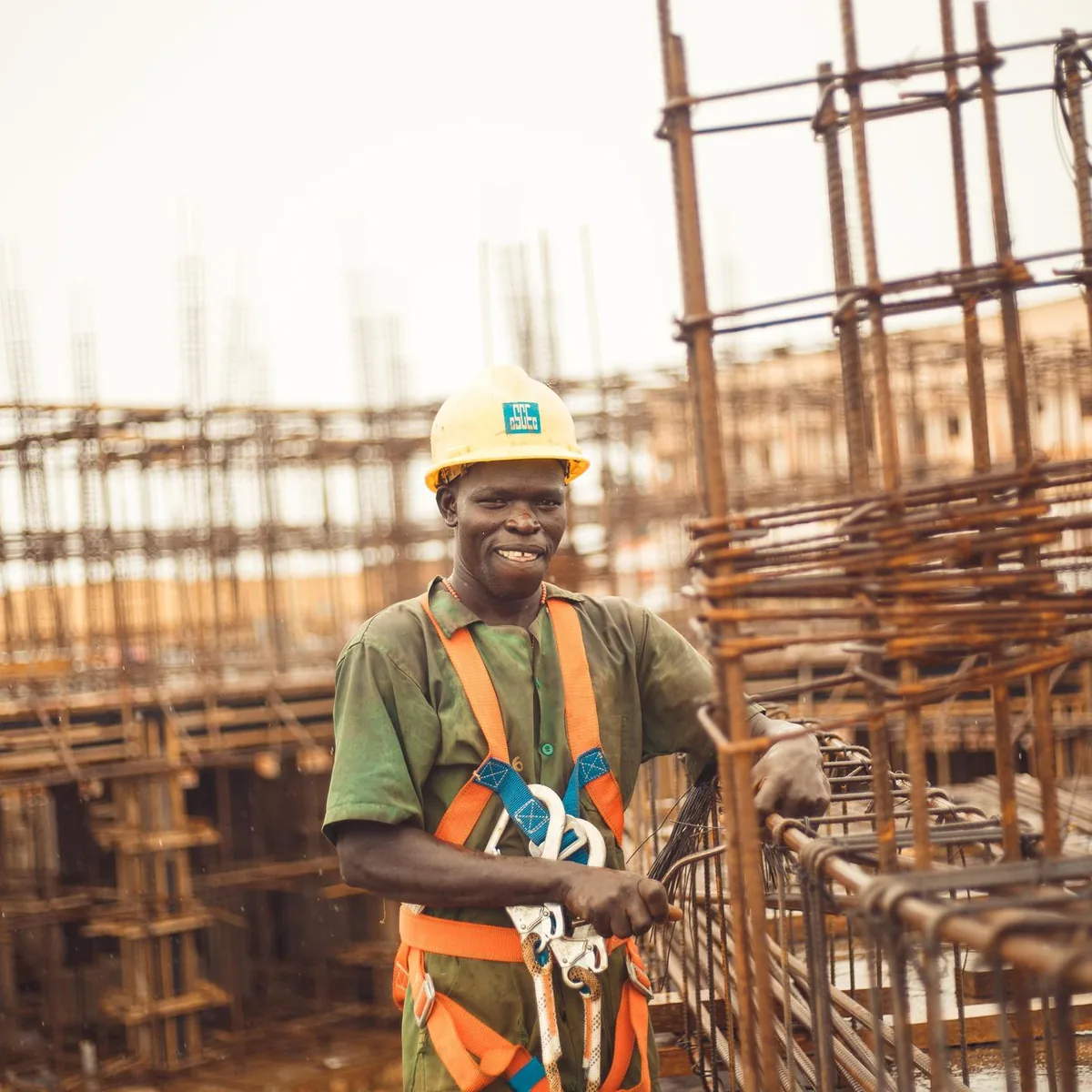 Construction worker in a hard hat and full-body safety harness on site